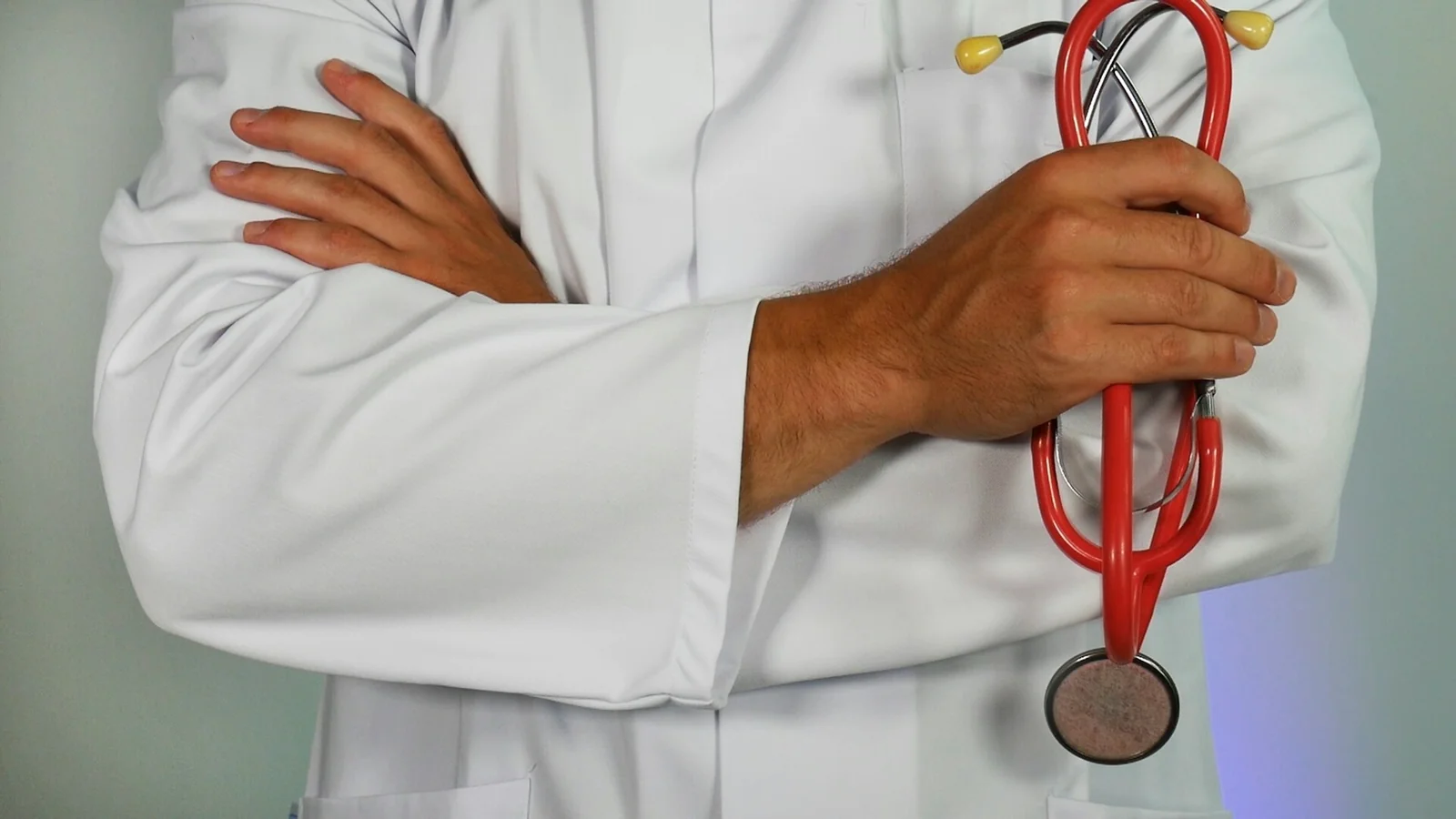 Clinician in a white coat holding a stethoscope